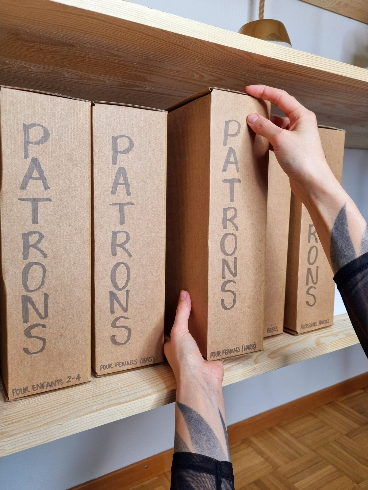 Boîtes de patrons rangées sur une étagère de l'atelier